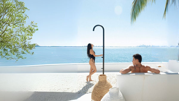 a couple enjoying tan outdoor shower in a matte black finish in a backyard overviewing the Miami intercoastal